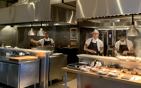 Three male chefs preparing food in restaurant kitchen