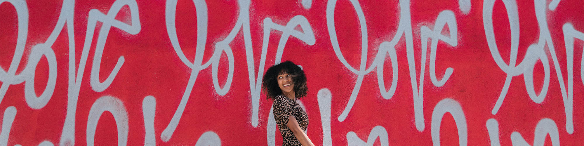 Women Standing In Front of Love Graffiti Wall