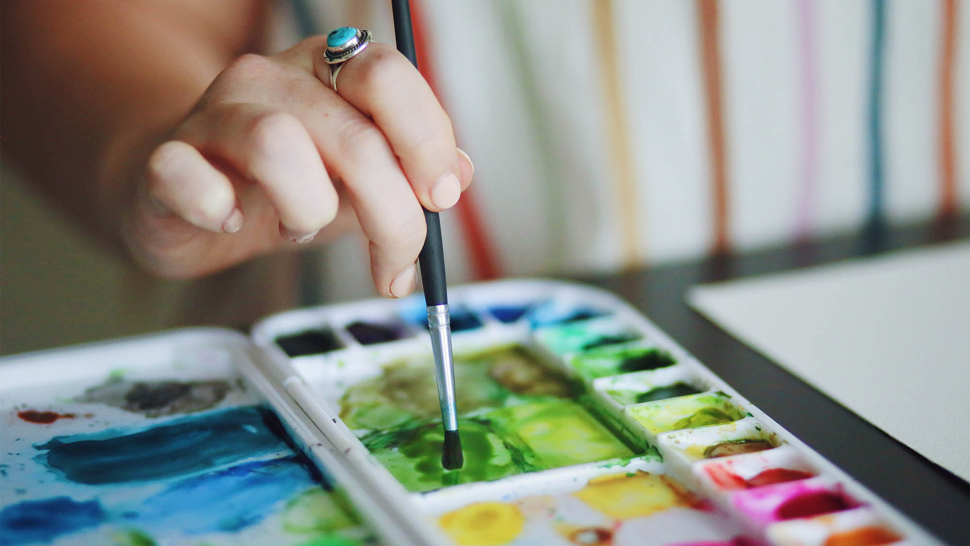 Female Hand Dipping Paintbrush in Palette