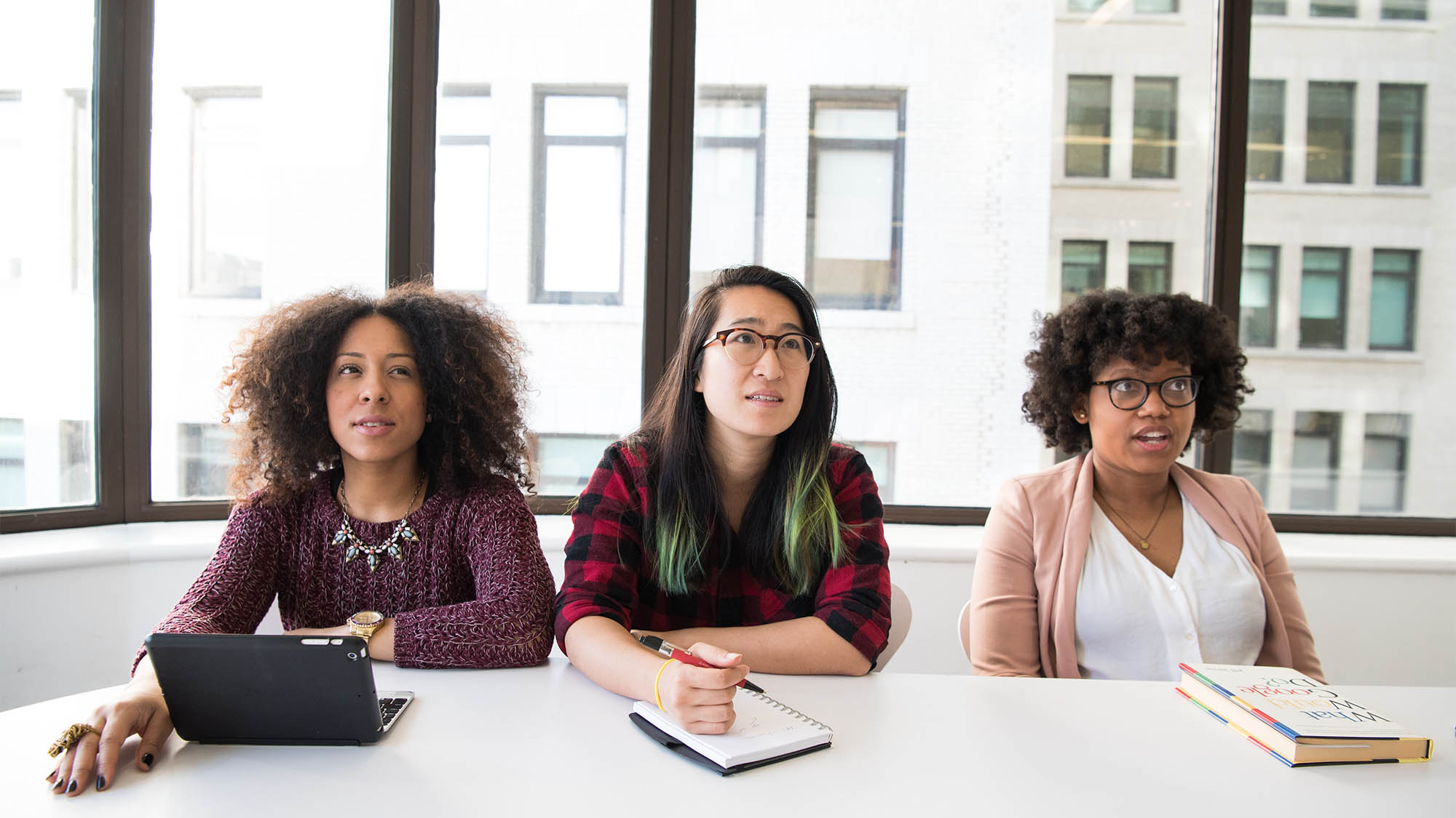 Three Women Sitting at Meeting Table