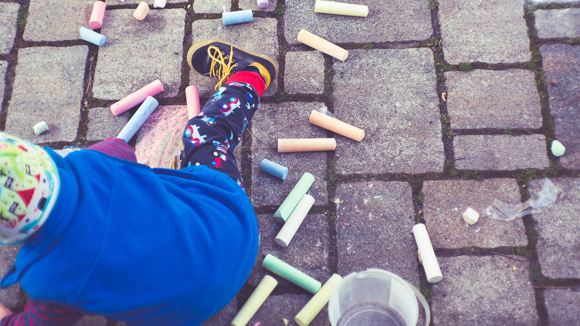 Little Boy Drawing with Chalk on Bricks