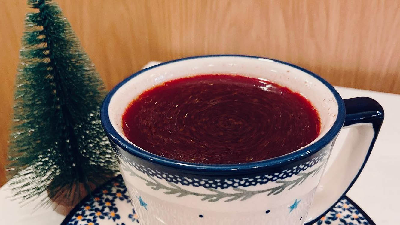 Cup of borscht next to mini Christmas tree