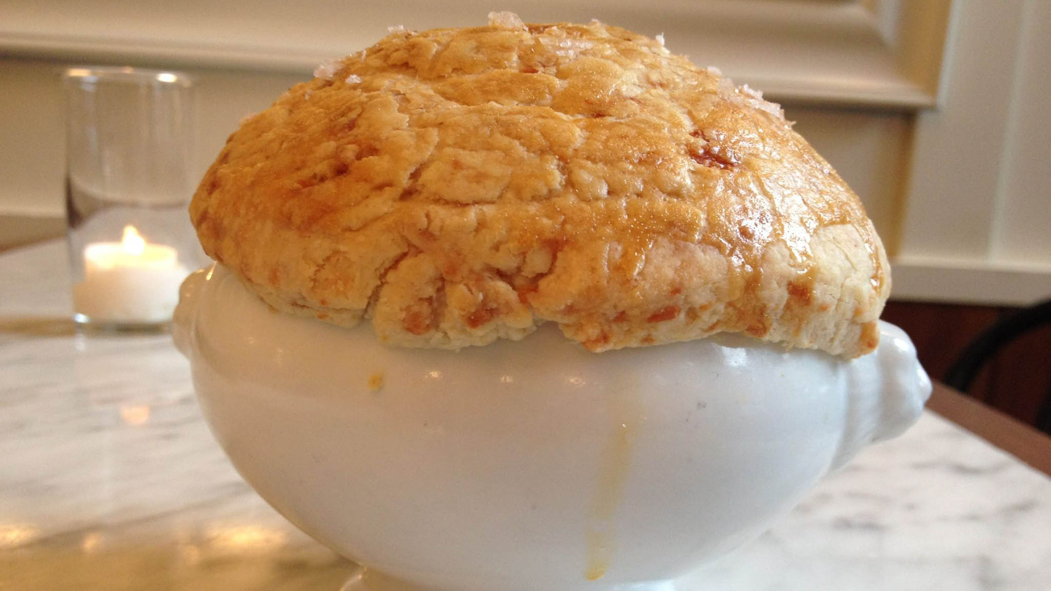 Closeup of soup en croute in white bowl