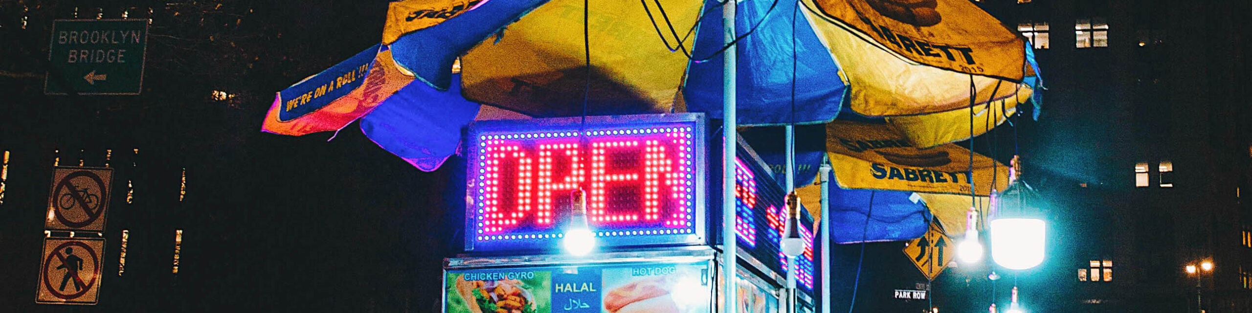 Lit up open sign closeup on Brookyln hot dog cart at night