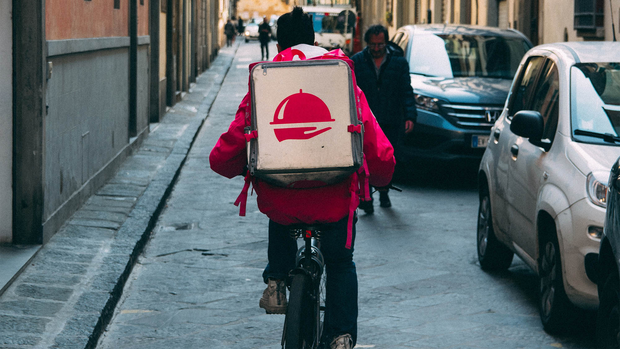 Back of bike courier driving down city street