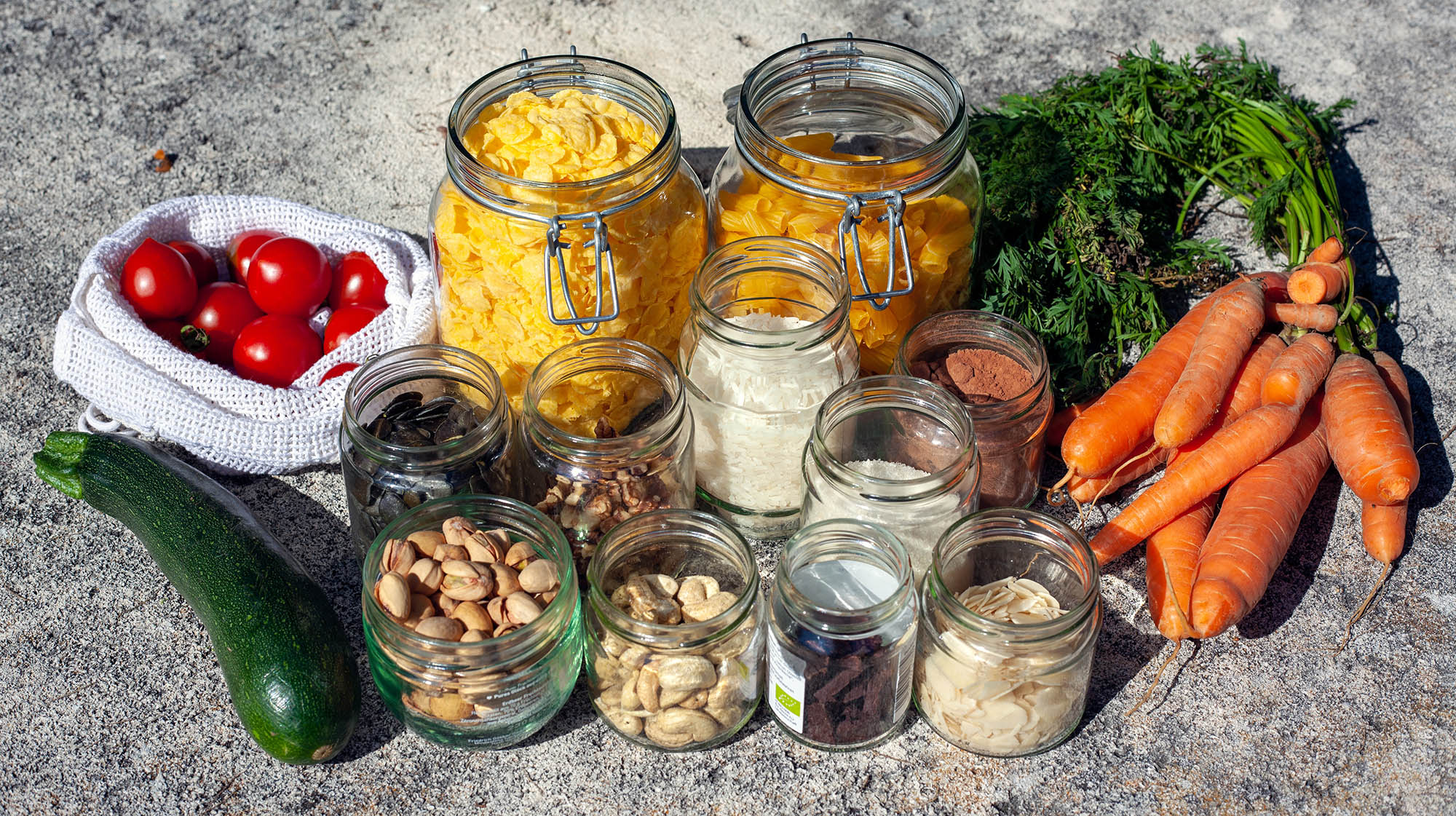 Variety of groceries in glass jars and reusable bags