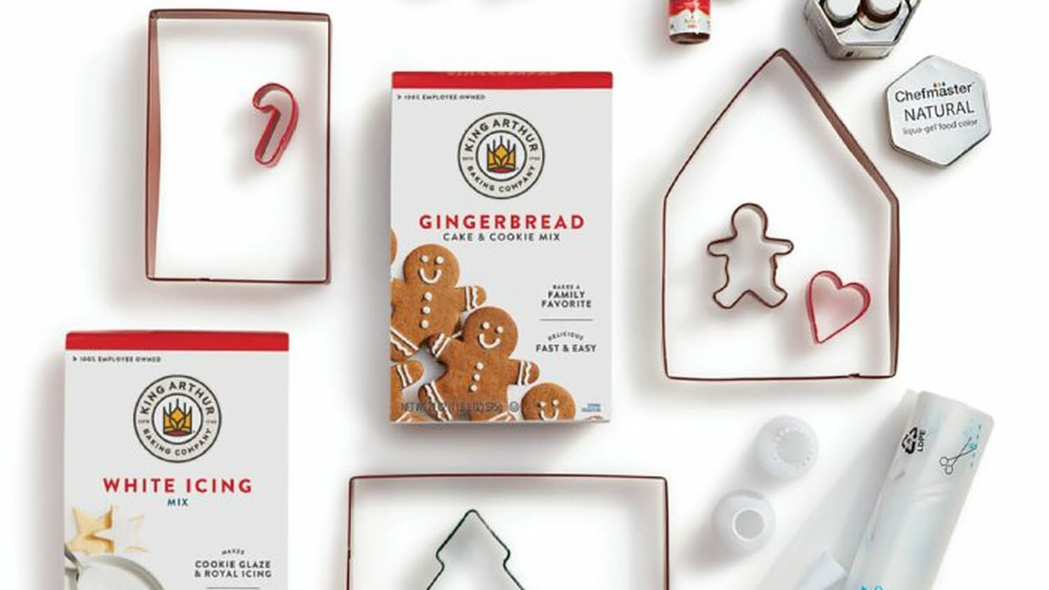 King Arthur brand gingerbread house mix with cookie cutters spread on white table