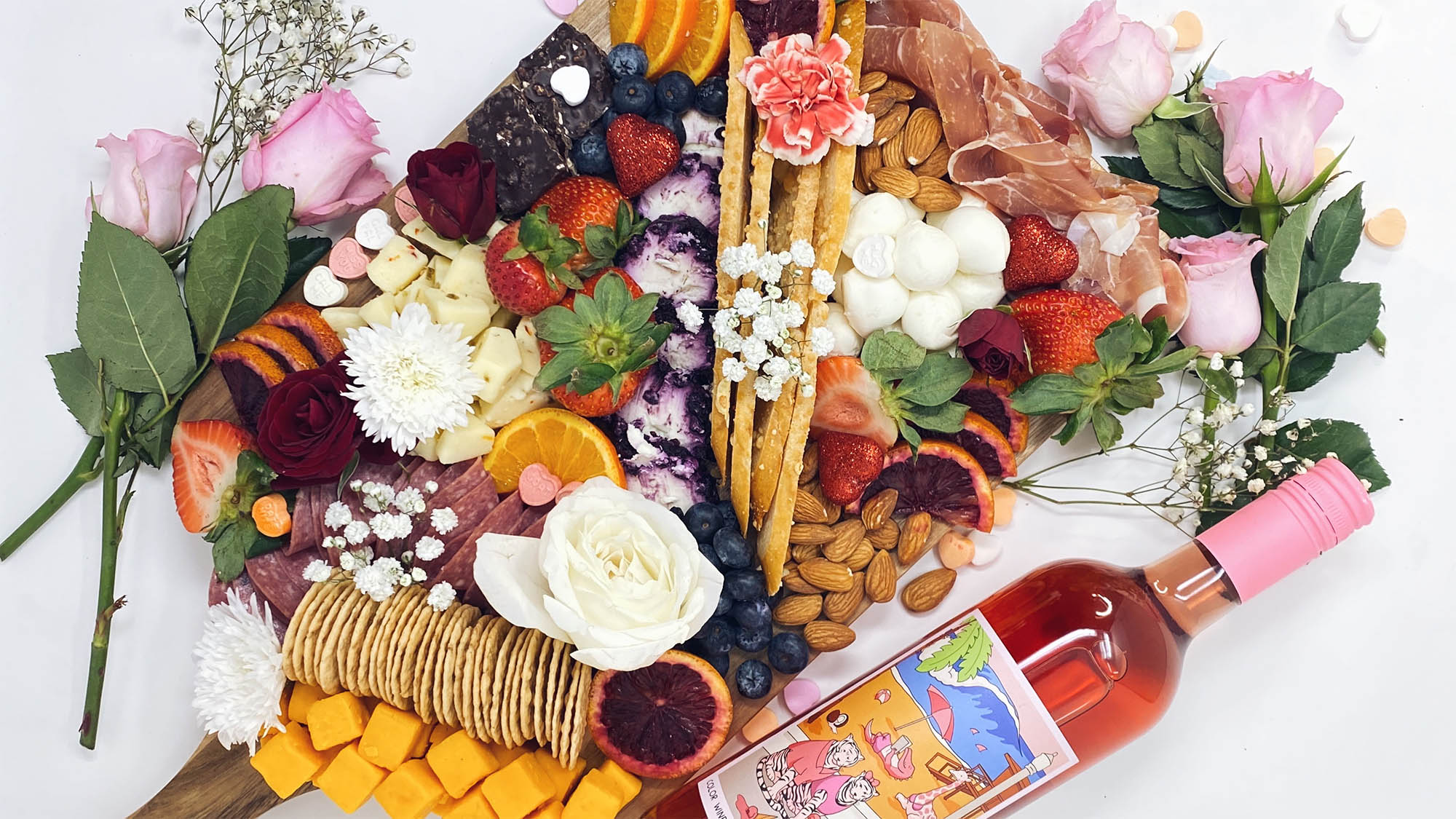 Charcuterie board with fruit crackers cheese and wine