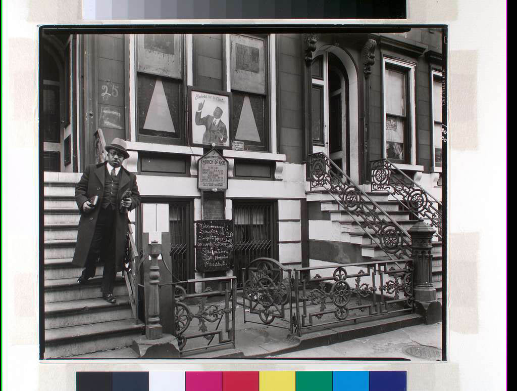 Black and white historical photo of Black man standing on stoop of Harlem Church of God
