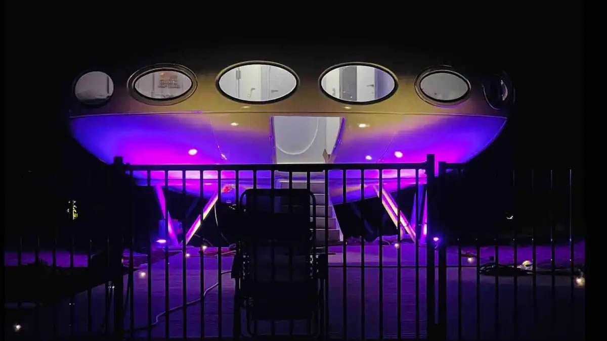 Exterior UFO-shaped Futuro hotel at night with purple lights