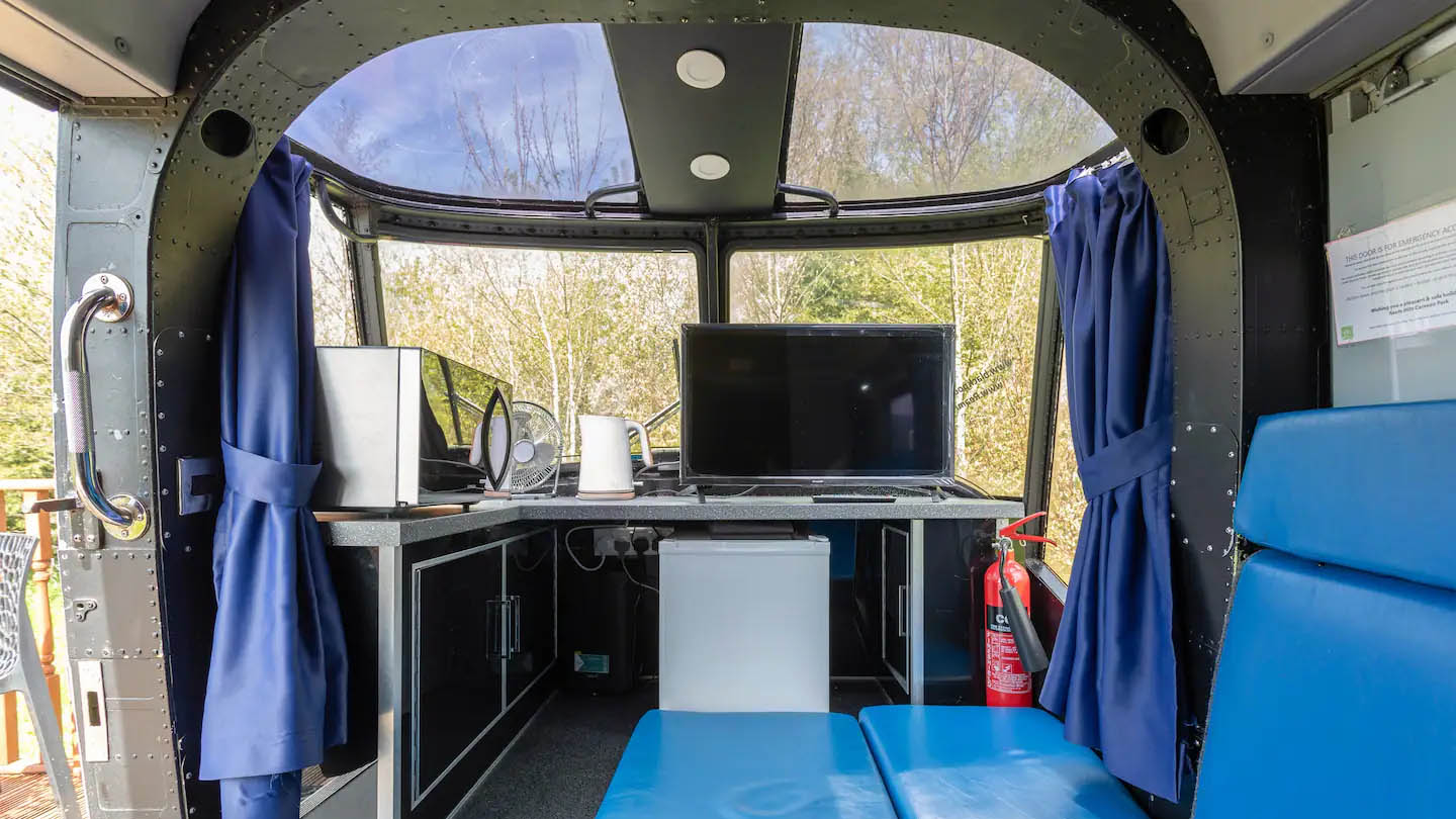 Helicopter vacation home interior with blue booth and flat screen tv underneath front windows