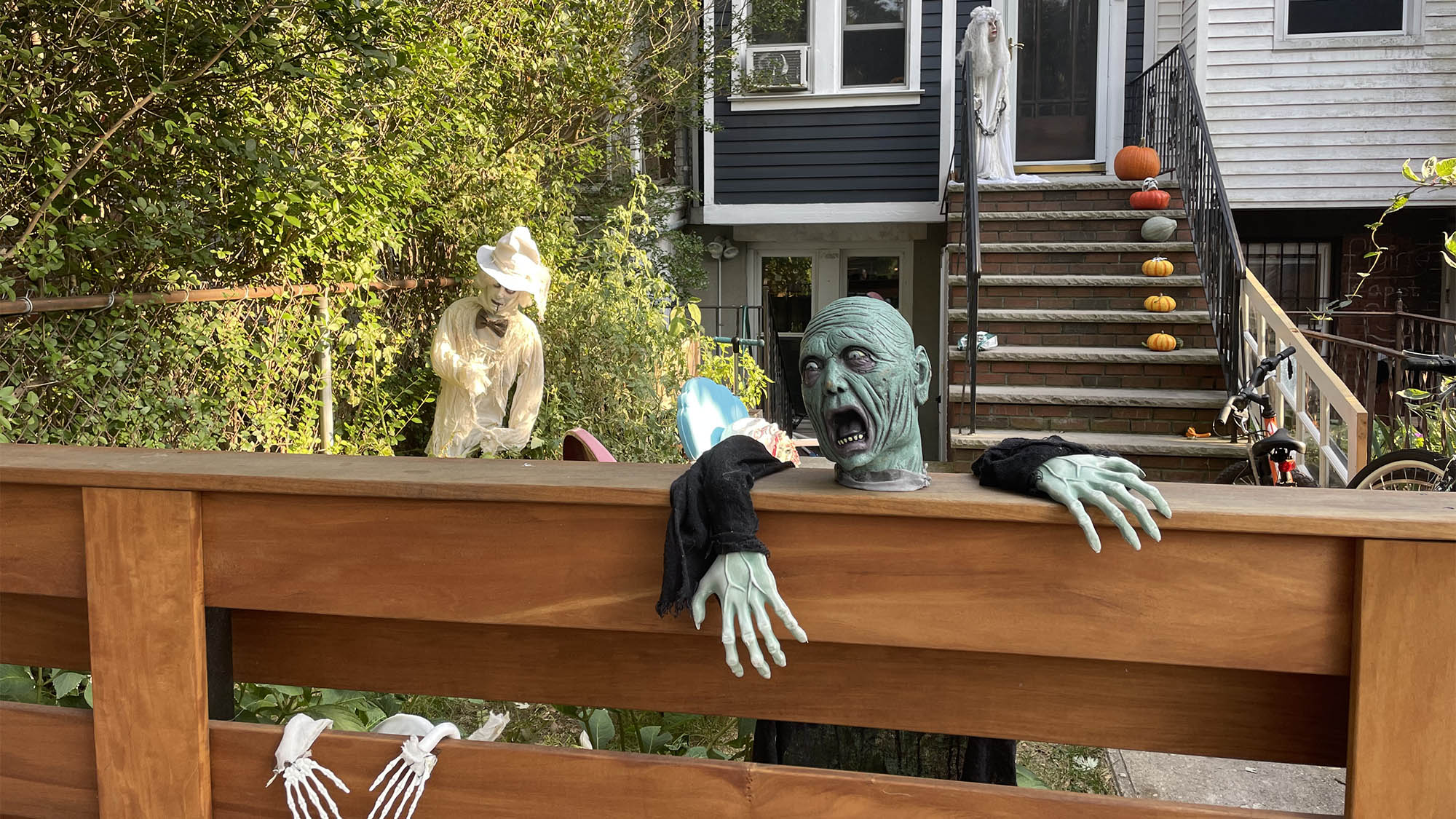 Zombie decoration hung over Brooklyn fence with house in background