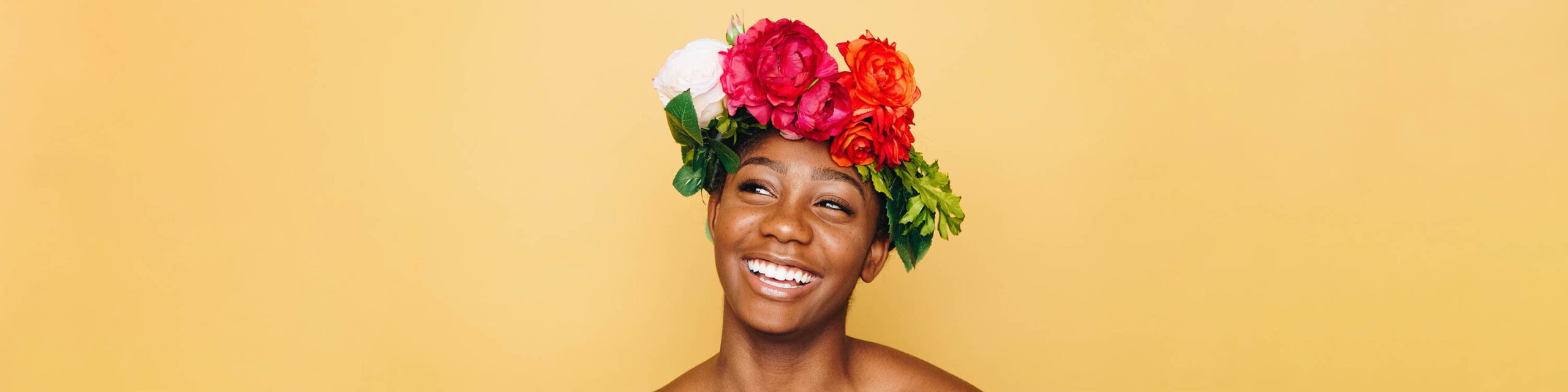Headshot of Black woman smiling with flower crown on head