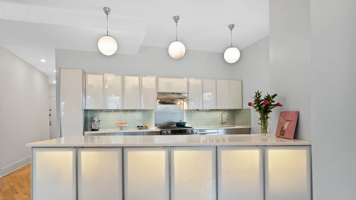Modern kitchen with three pendant lights and backlit cabinets