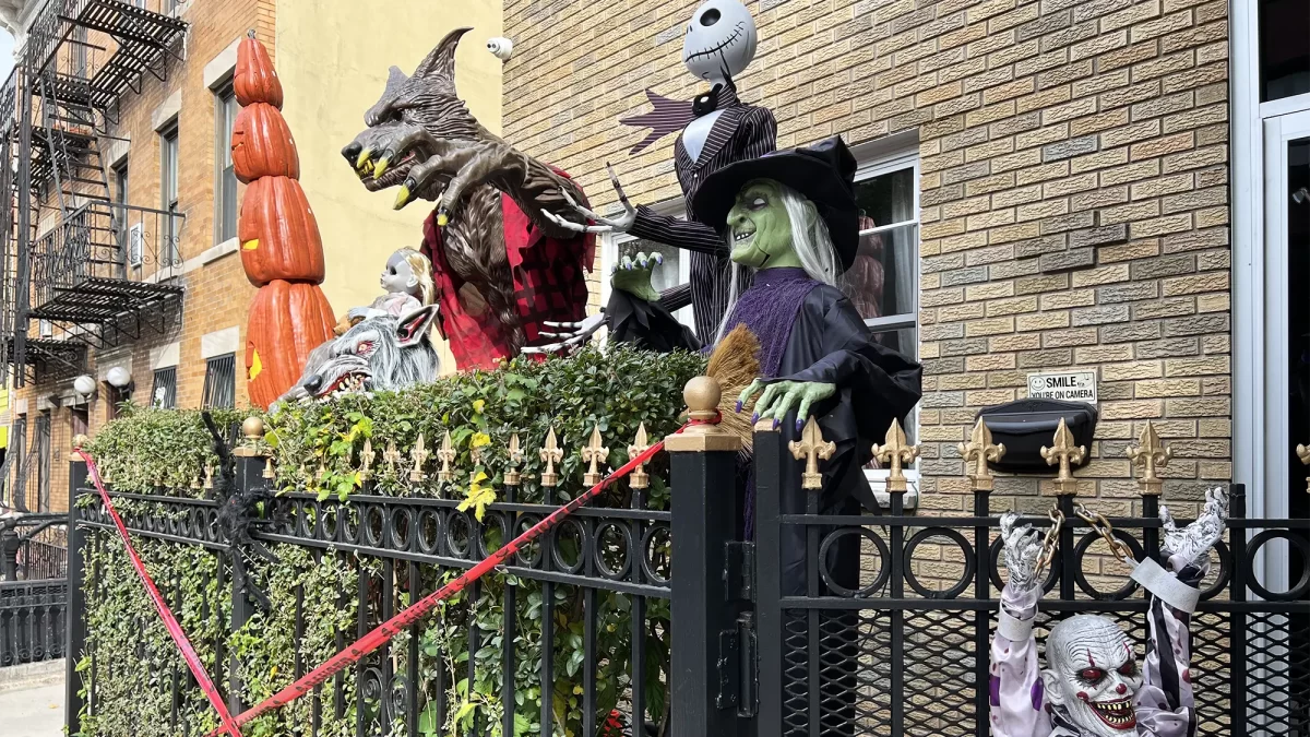 Halloween decorations in front of gated brick city home