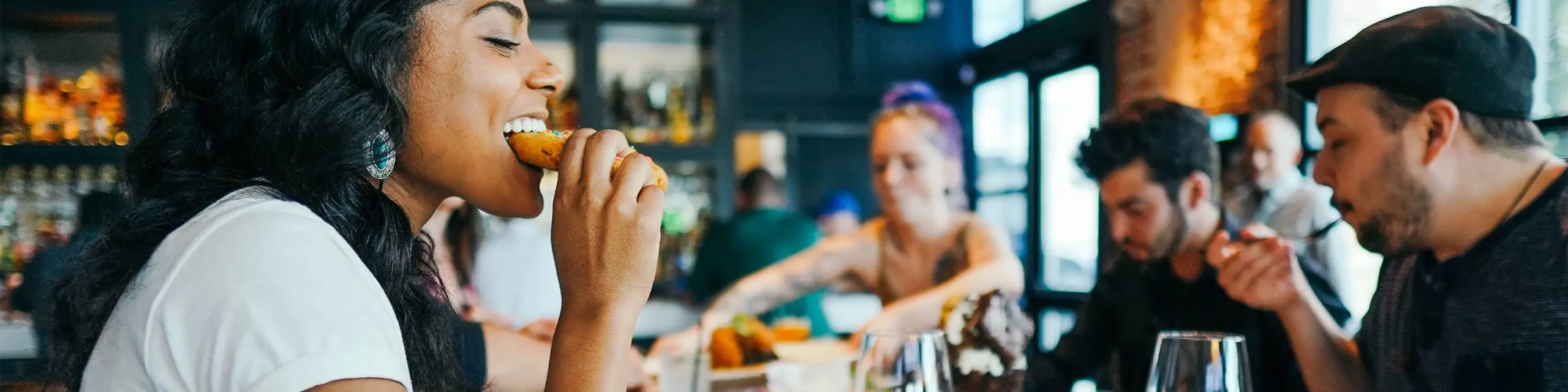 Two women and two men eating at restaurant table