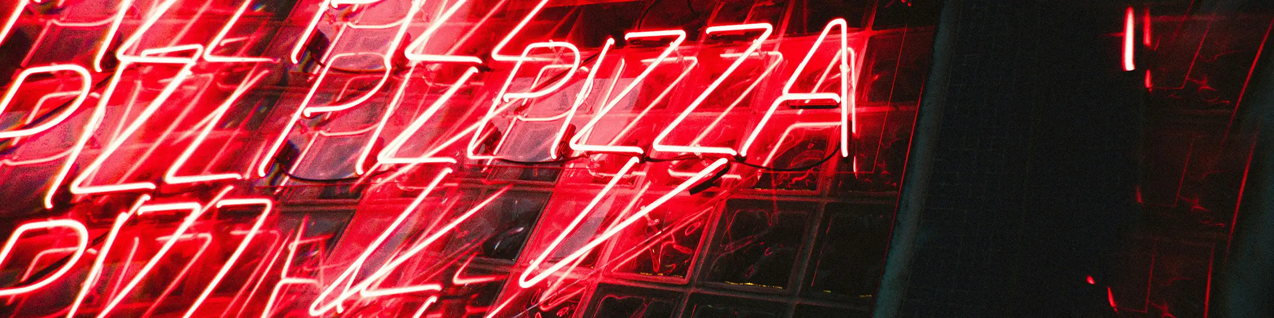 Repeating neon signs of the word "pizza"