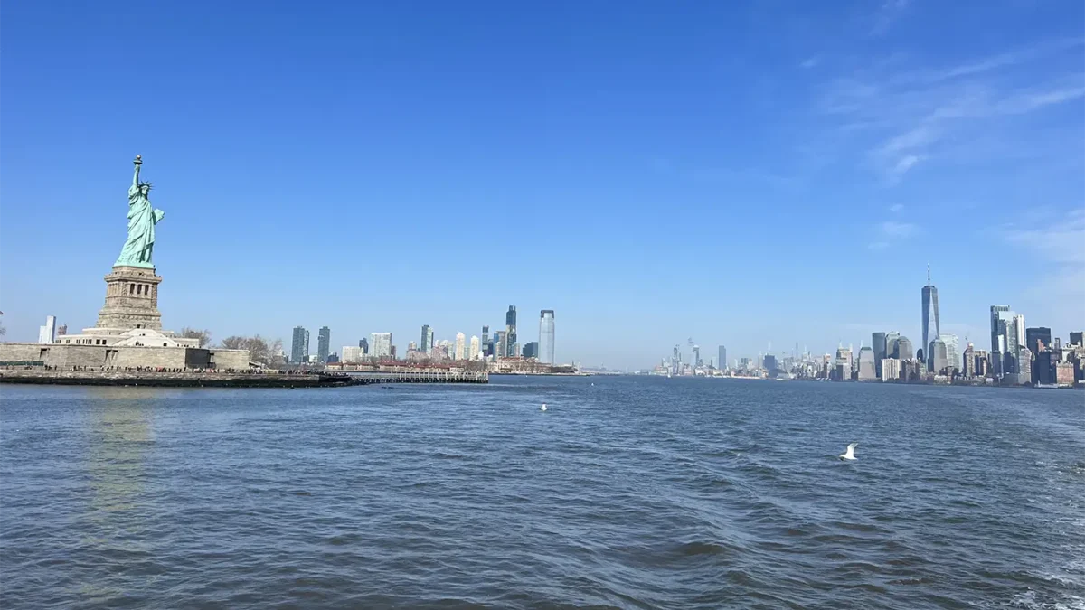 Statue of liberty and NYC skyline view from boat in the water