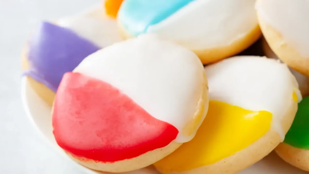 Pride cookies with half white and half different colored frosting