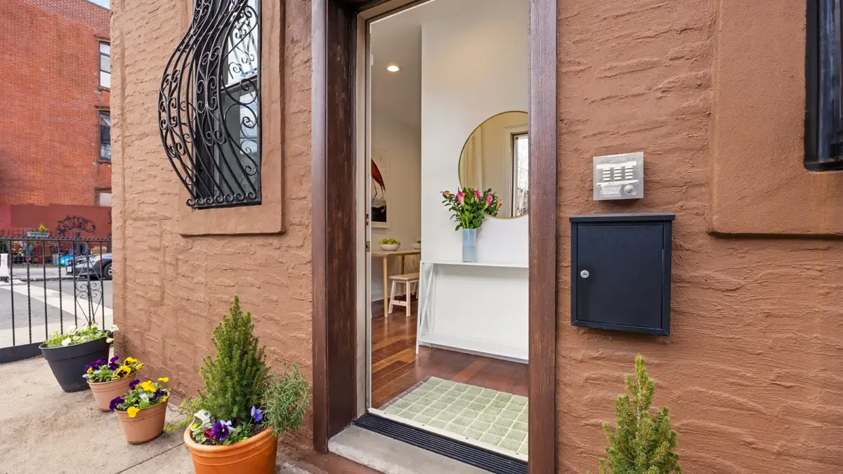 Brownstone building with front door open 