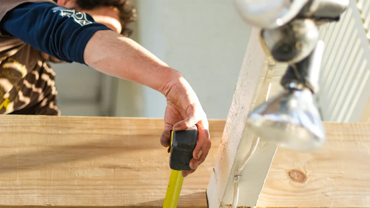 White man's arm measuring wood 