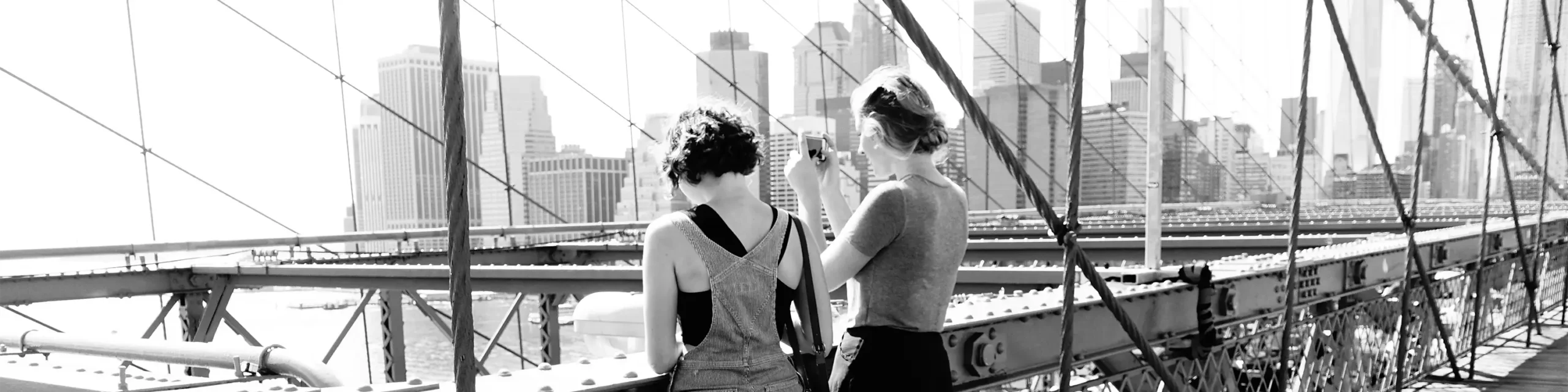 Two women standing on Brooklyn Bridge