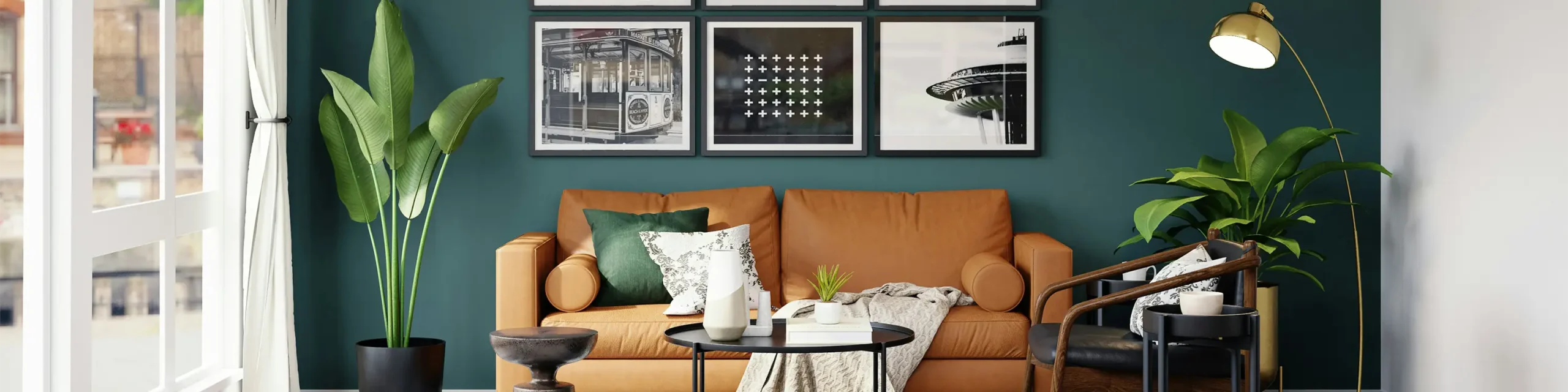Brown leather couch against green wall with framed artwork