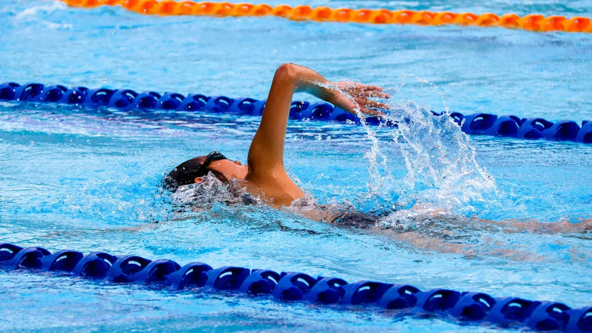 Person swimming in pool lane