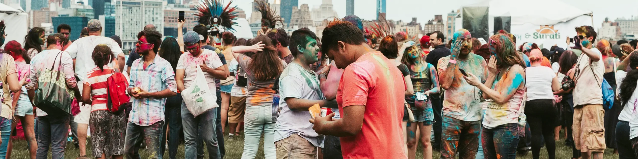 Crowd throwing colored Holi powder outdoors