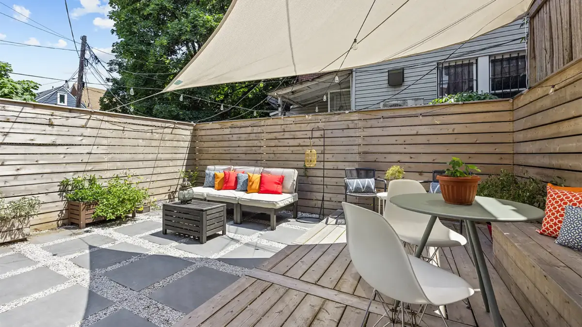Patio with couch in sign and table and chairs under shade