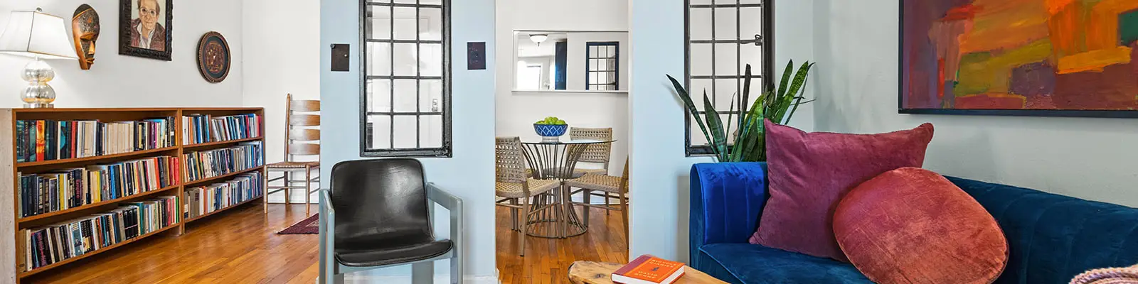 Living room with bookshelf on left, chair in middle and couch on right