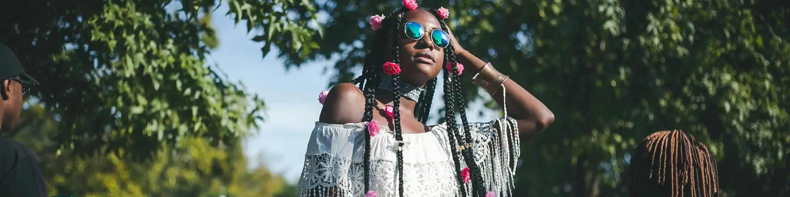 Black women with sunglasses on outside under tree