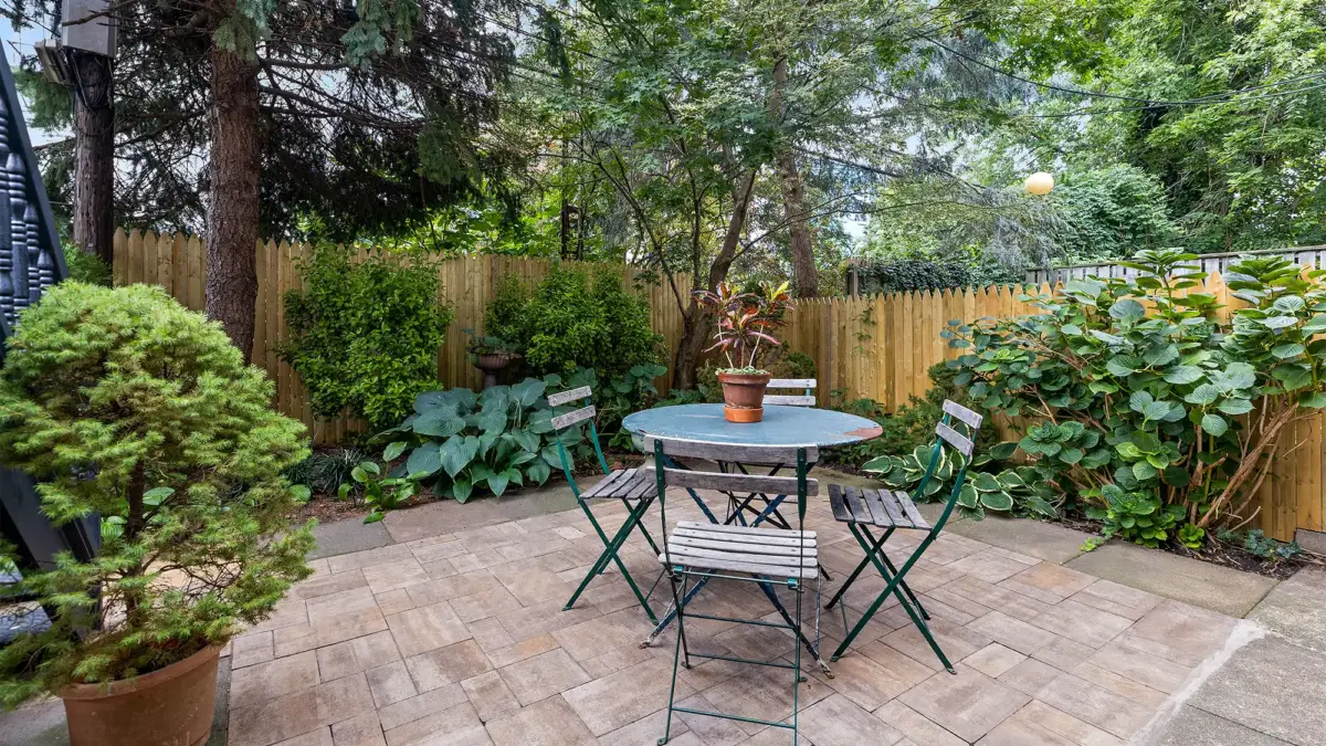 Brooklyn home garden courtyard with table and chairs surrounded by lush green plants