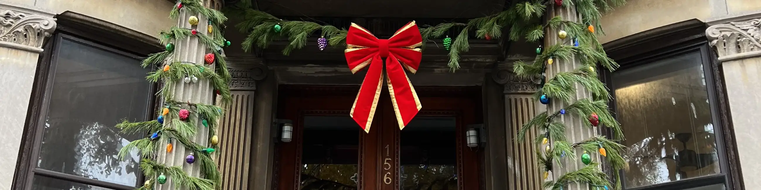 Brownstone entryway with holiday garland and red bow