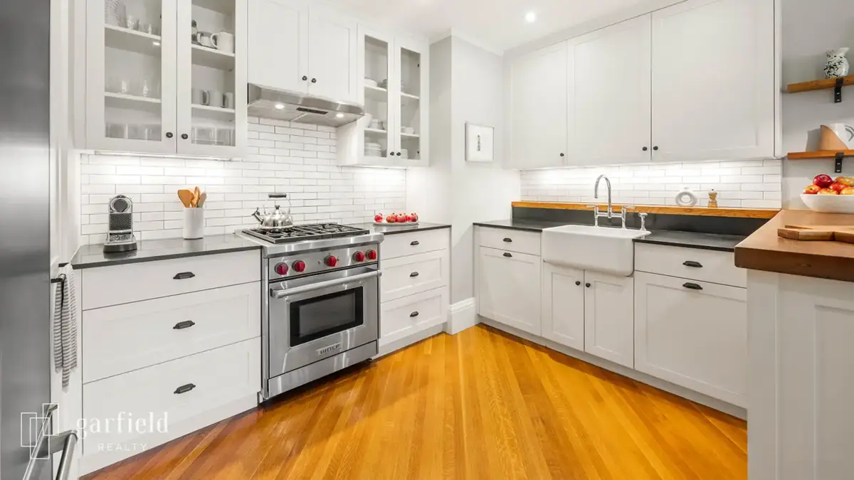 Modern kitchen with stainless steel appliances, white cabinets and apron-front sink